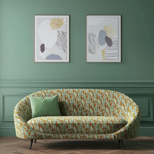 Green patterned fabric sofa with artwork